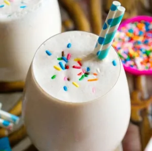 Delicious cake batter protein shake with vibrant toppings in a glass
