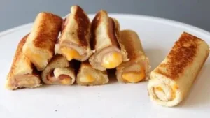 Delicious grilled cheese roll-ups served on a plate with a crispy golden crust