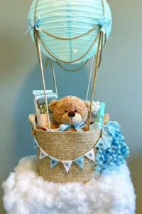 Stunning hot air balloon baby shower gift basket with colorful decorations and gifts.