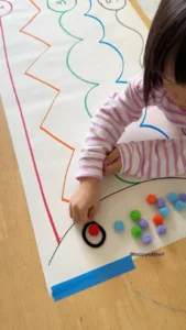 Preschoolers sorting pompoms in a colorful counting activity setup