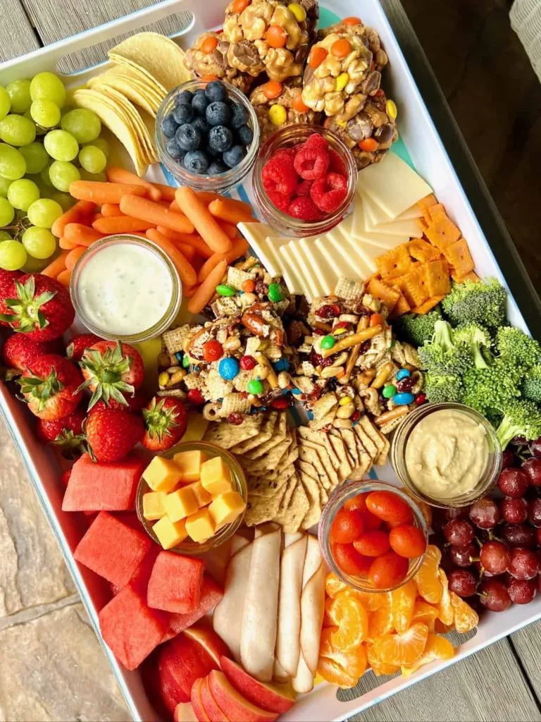 Delicious picnic food for kids arranged on a blanket in a park setting.