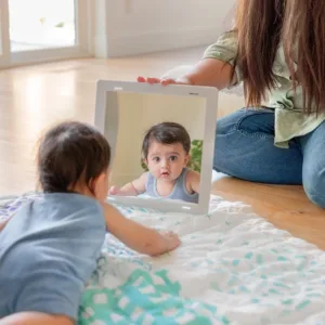 Baby enjoying tummy time with fun toys and a supportive parent