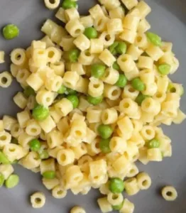 Creamy Parmesan Pea Pasta dish topped with fresh peas and grated cheese