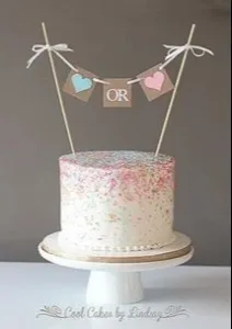 Delicious gender reveal cake with pink and blue decorations for a party.