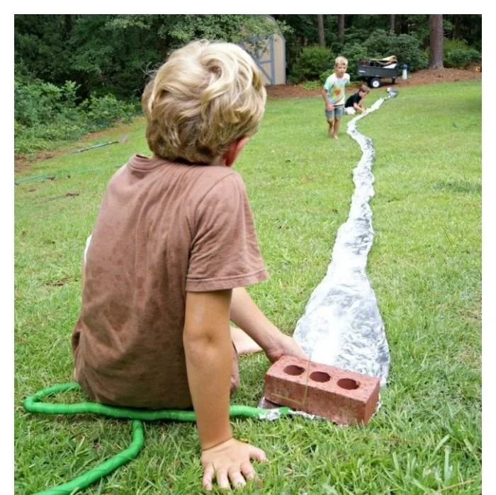 Kids creating Tinfoil Rivers for fun and learning activities.