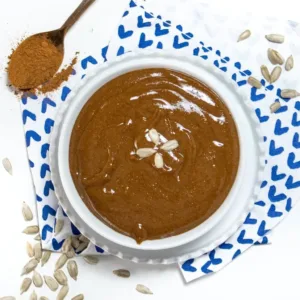 Homemade spiced sunflower seed butter in a jar with toppings, ideal for busy moms.