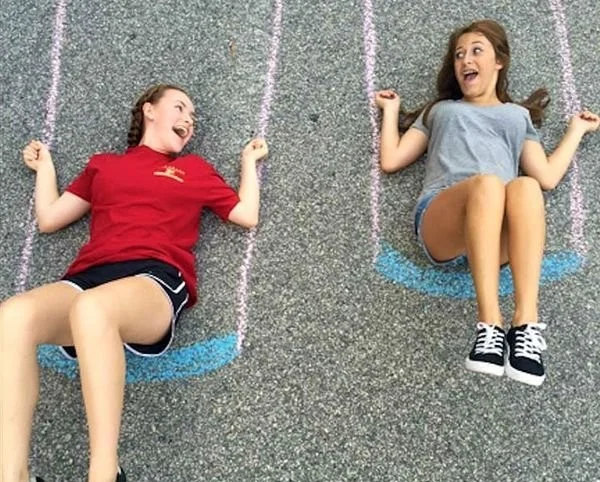Colorful sidewalk chalk art designs created by kids on pavement.