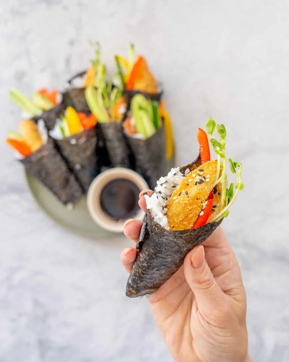 A delicious assortment of hand roll sushi displayed on a wooden platter.