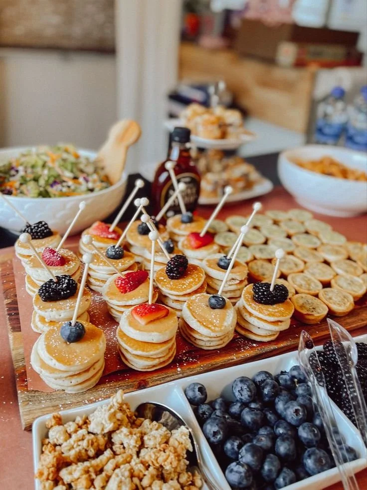 Mini pancakes served at a baby shower brunch with fresh fruit and syrup.