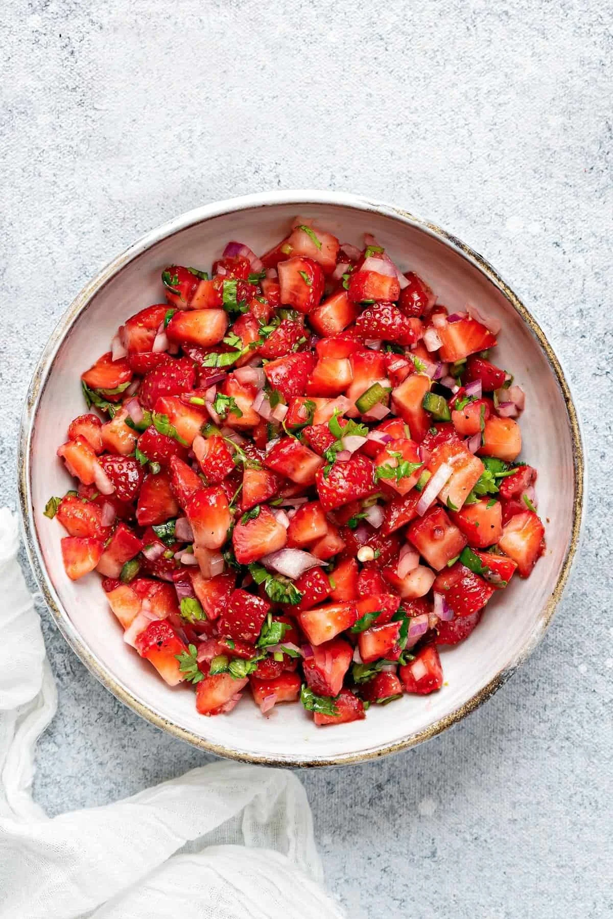 Colorful strawberry salsa served in a bowl with tortilla chips.