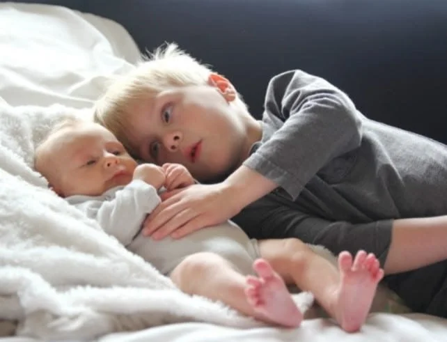 Toddler adjusting to being a big sibling with a new baby sibling